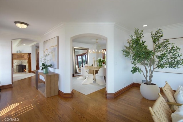 corridor featuring ornamental molding, dark hardwood / wood-style flooring, and a chandelier