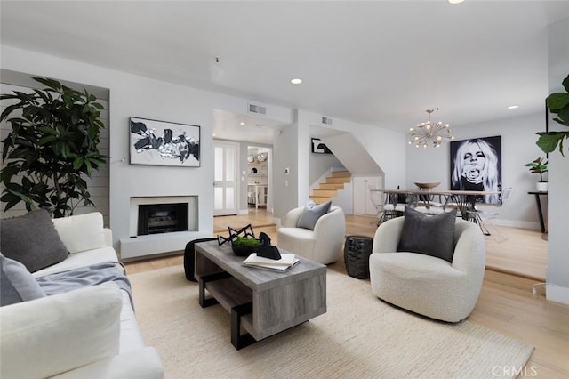 living room with an inviting chandelier and light wood-type flooring