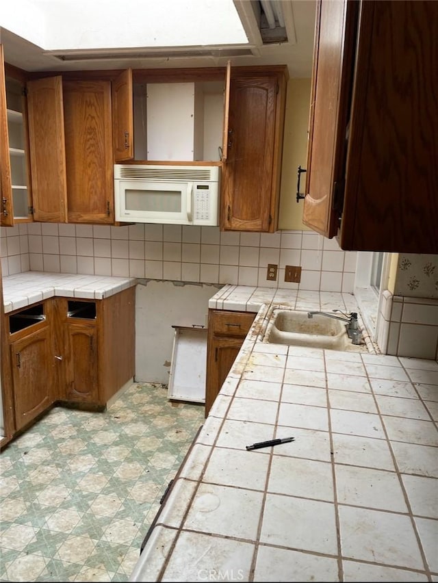 kitchen featuring sink, tile countertops, and backsplash