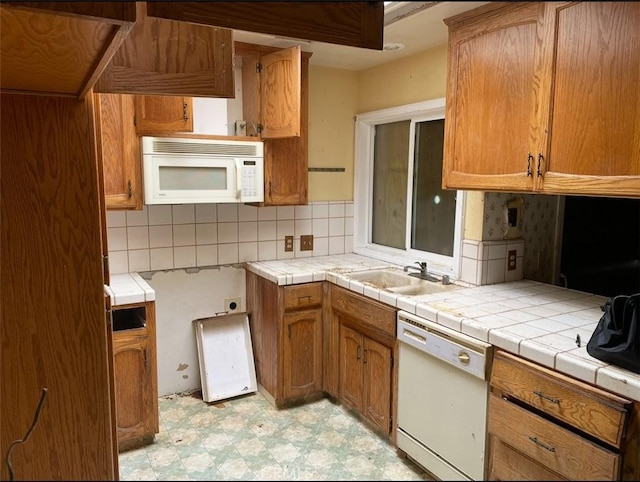 kitchen featuring sink, tile countertops, white appliances, and decorative backsplash