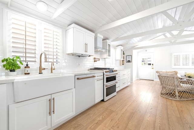 kitchen featuring double oven range, tasteful backsplash, a sink, white cabinets, and vaulted ceiling with beams