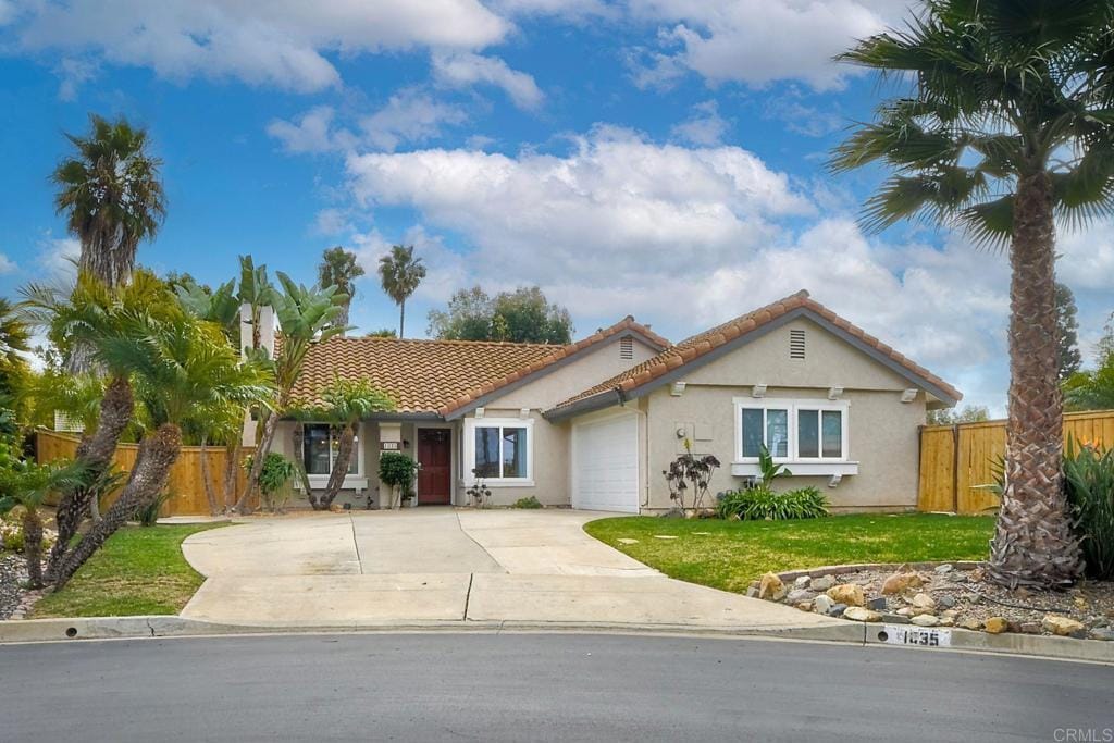 view of front of house featuring a garage and a front lawn