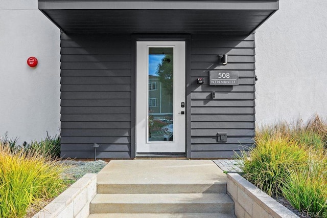 entrance to property featuring stucco siding