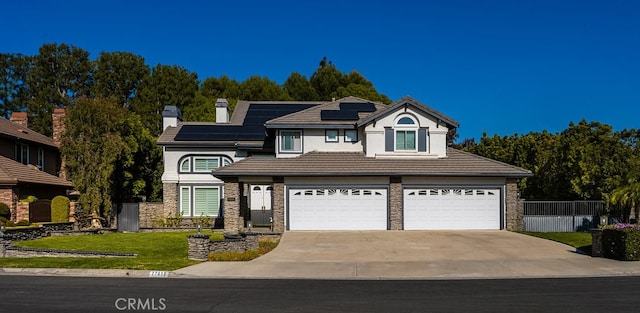 view of front facade featuring stone siding, concrete driveway, a tiled roof, roof mounted solar panels, and a front lawn