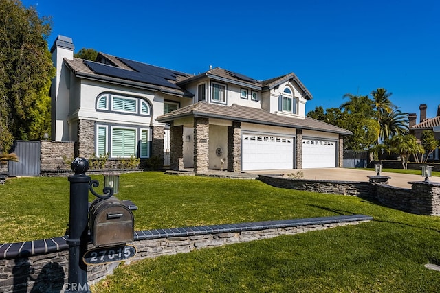 view of front facade featuring solar panels, a front yard, fence, stone siding, and driveway