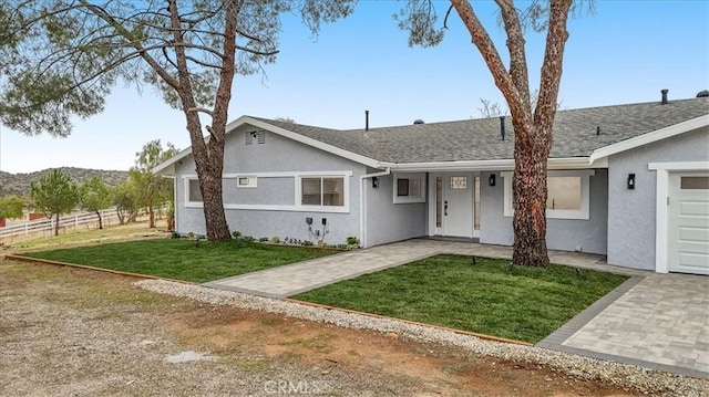 ranch-style home with a garage and a front lawn