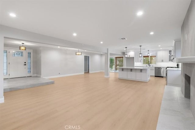 unfurnished living room with sink and light hardwood / wood-style flooring