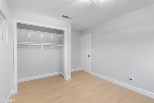 unfurnished bedroom featuring light hardwood / wood-style floors and a closet