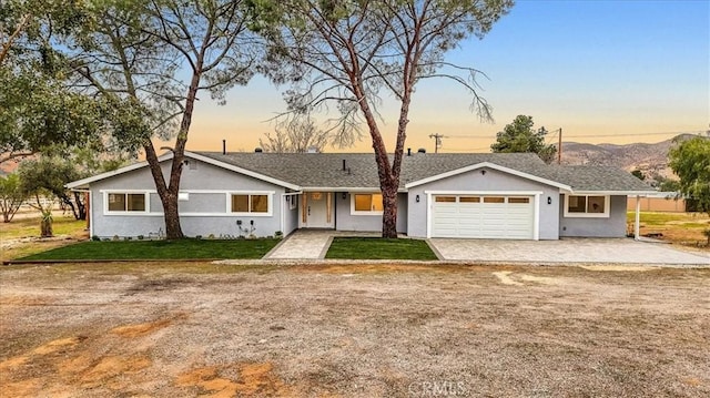 ranch-style house featuring a garage and a lawn