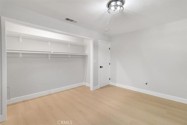 unfurnished bedroom with wood-type flooring and a closet