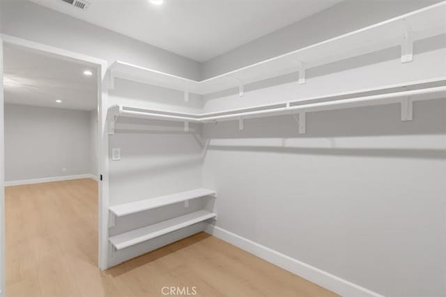 walk in closet with wood-type flooring