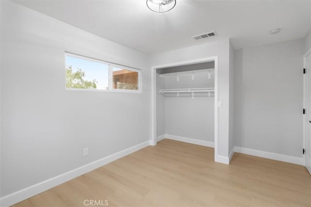 unfurnished bedroom featuring a closet and light wood-type flooring