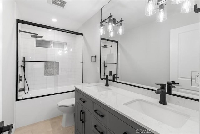 full bathroom with toilet, vanity, and bath / shower combo with glass door