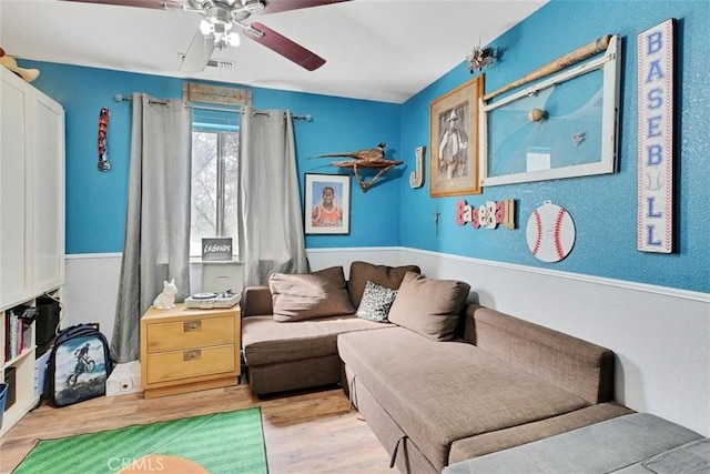 living area with ceiling fan and light hardwood / wood-style floors