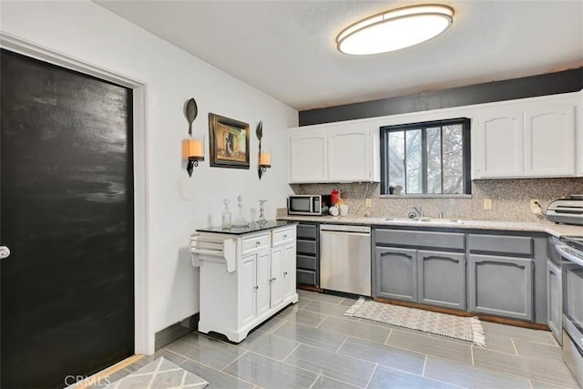 kitchen with appliances with stainless steel finishes, white cabinets, and gray cabinetry