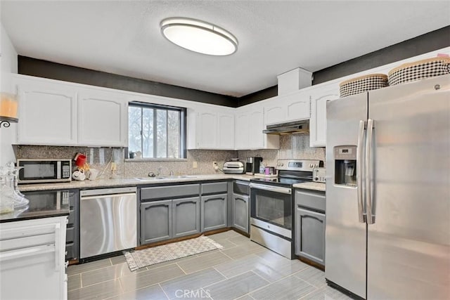 kitchen featuring white cabinetry, backsplash, gray cabinets, and stainless steel appliances