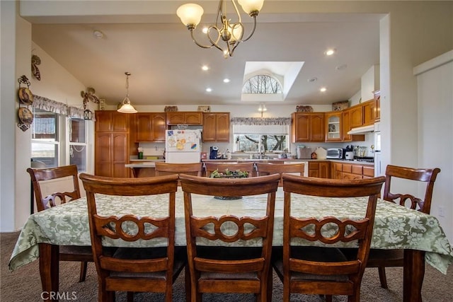 dining space featuring an inviting chandelier, carpet flooring, and high vaulted ceiling