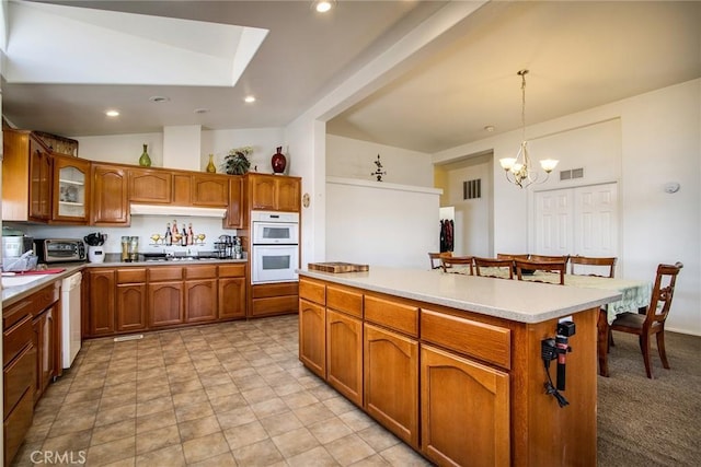 kitchen featuring vaulted ceiling, pendant lighting, a chandelier, a center island, and white appliances