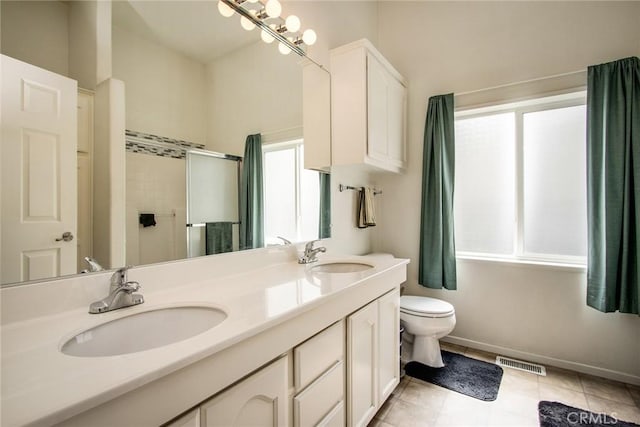 bathroom featuring vanity, a shower with shower door, tile patterned floors, and toilet