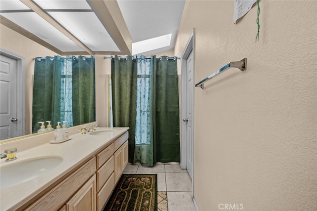 bathroom featuring tile patterned flooring, vanity, and a skylight