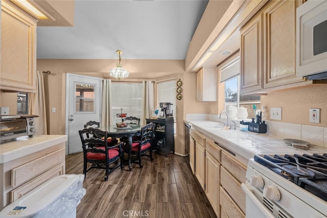 kitchen featuring sink, tile counters, white appliances, and decorative light fixtures