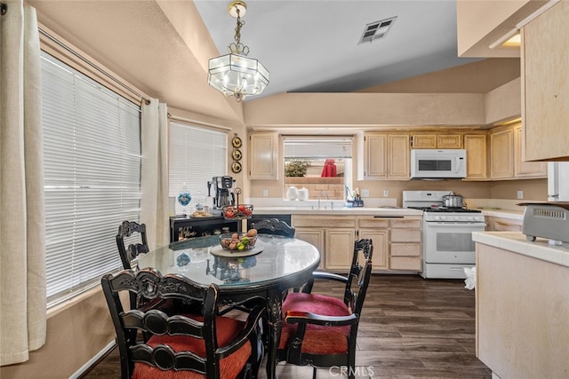 kitchen featuring dark wood-type flooring, light brown cabinetry, vaulted ceiling, hanging light fixtures, and white appliances