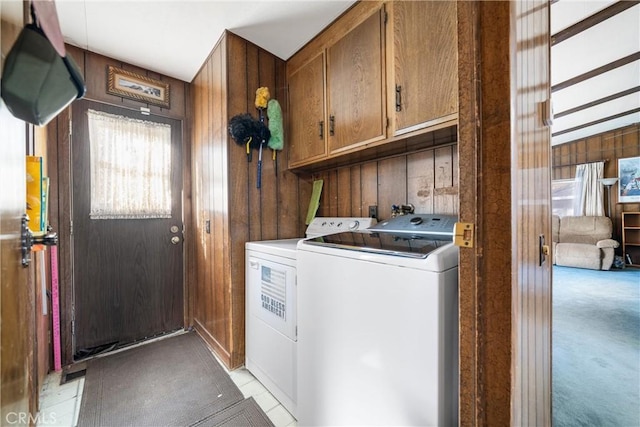 laundry area featuring cabinets, washing machine and dryer, light colored carpet, and wooden walls