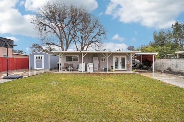 rear view of property with a patio, a yard, a storage shed, and french doors