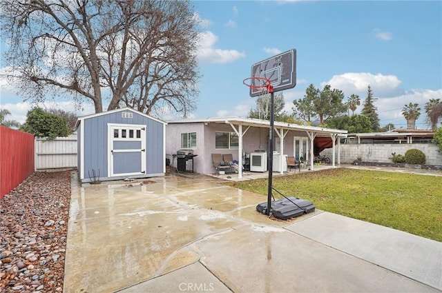 view of basketball court with a storage shed, a patio area, and a lawn