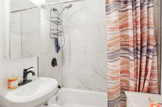 bathroom with shower / bathtub combination with curtain and sink