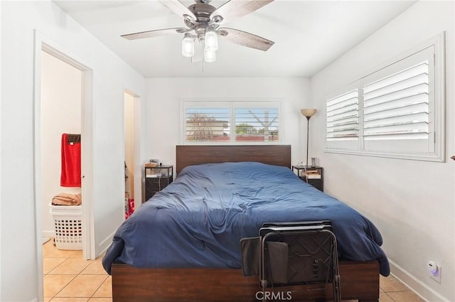 tiled bedroom featuring ceiling fan and connected bathroom