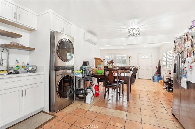 laundry area with stacked washer / dryer, a wall mounted air conditioner, sink, and light tile patterned floors