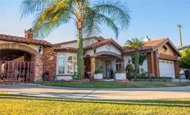 mediterranean / spanish home with a garage and a front yard