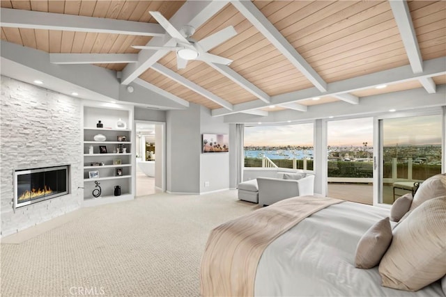 carpeted bedroom with a large fireplace, vaulted ceiling with beams, and wood ceiling