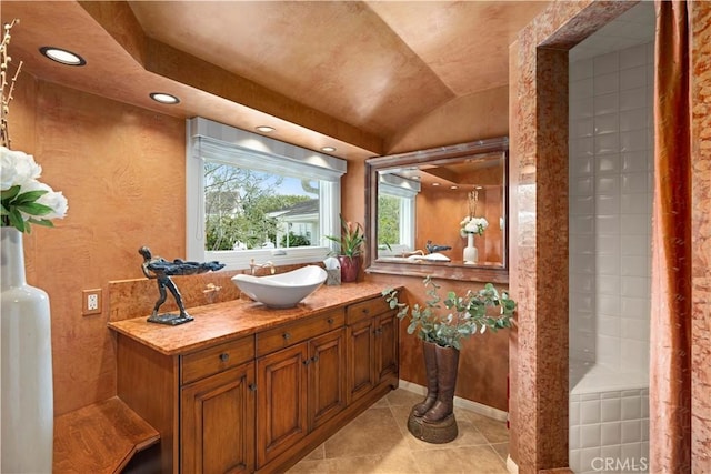 bathroom with tile patterned floors, vanity, a shower, and lofted ceiling