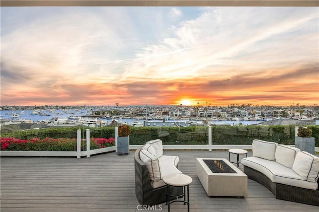 deck at dusk featuring an outdoor living space with a fire pit