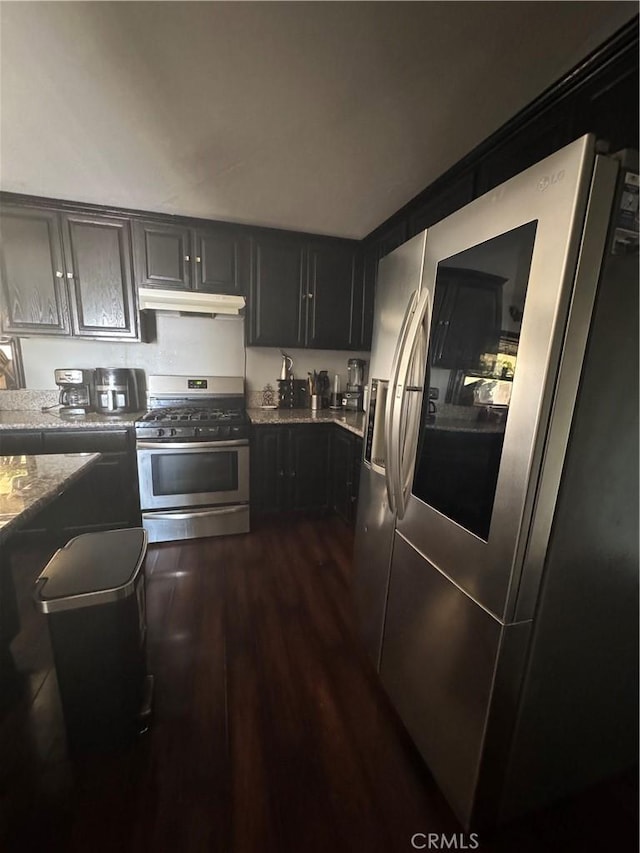 8734 Nevada Rd, Phelan, CA 92371 - kitchen featuring dark wood-style flooring, under cabinet range hood, light stone counters, and stainless steel appliances