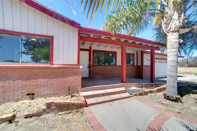 doorway to property featuring a garage and a porch