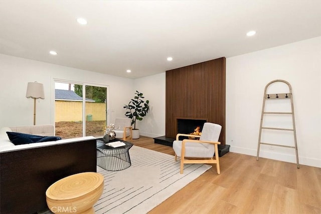 sitting room with a fireplace and light hardwood / wood-style flooring