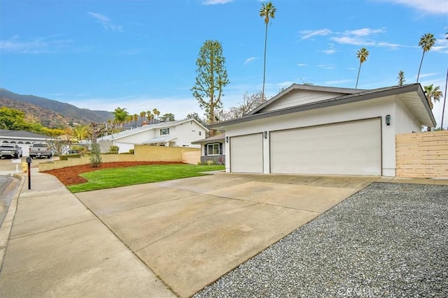 view of front of house with a garage, a mountain view, and a front yard