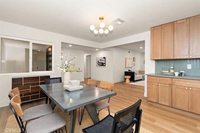 dining space with a chandelier and light hardwood / wood-style flooring