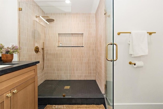 bathroom featuring walk in shower and vanity