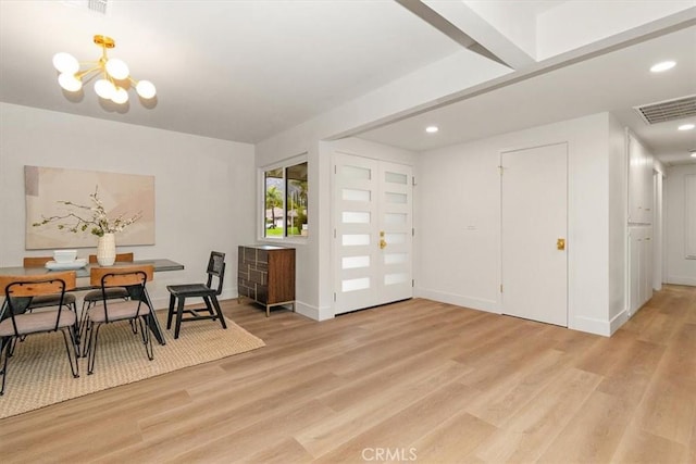 dining space featuring an inviting chandelier and light wood-type flooring