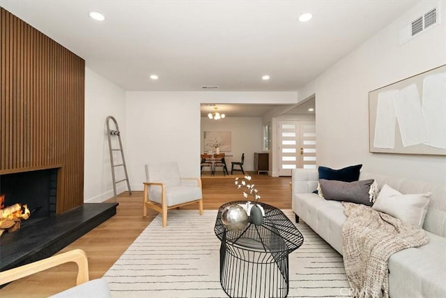 living room with an inviting chandelier and light wood-type flooring