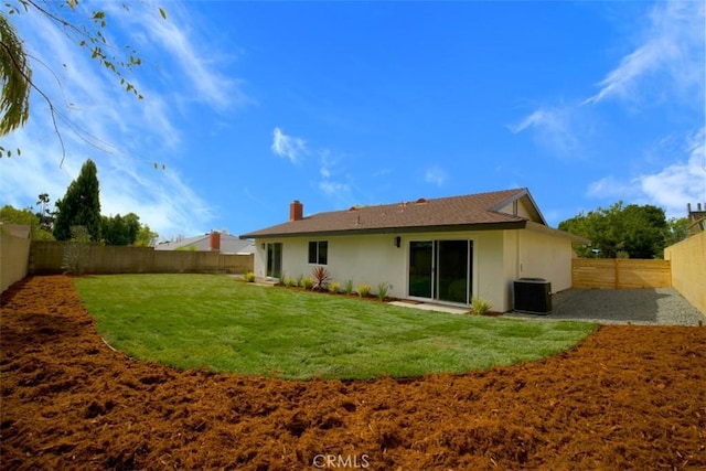 rear view of house featuring cooling unit and a lawn