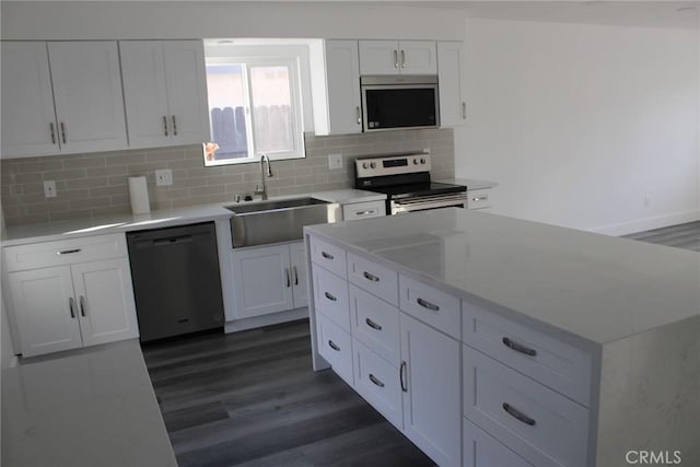 kitchen featuring light countertops, appliances with stainless steel finishes, a sink, and white cabinets