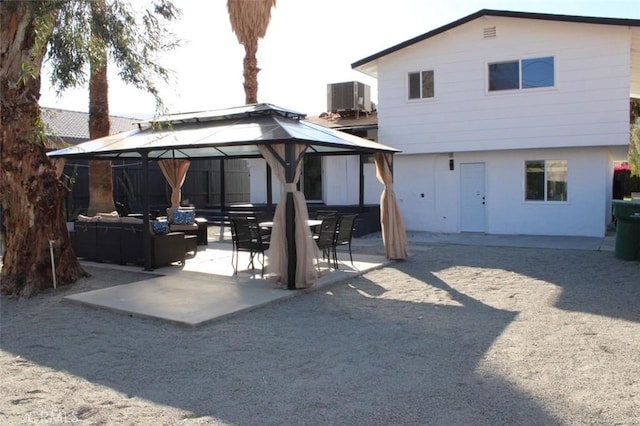 rear view of house featuring central AC unit, an outdoor living space, and a gazebo