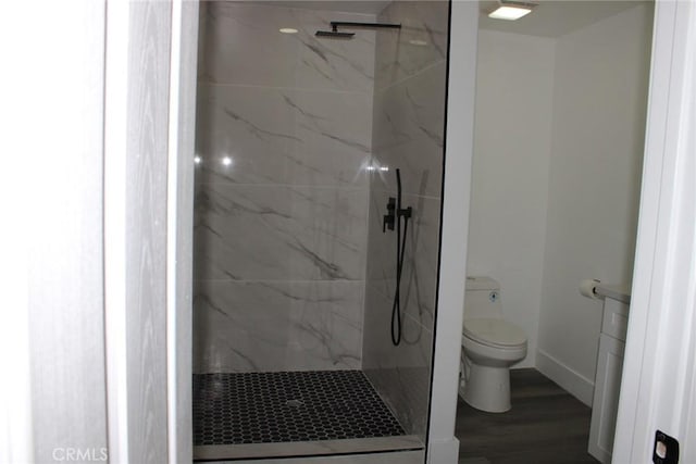 full bath with toilet, a marble finish shower, baseboards, and wood finished floors