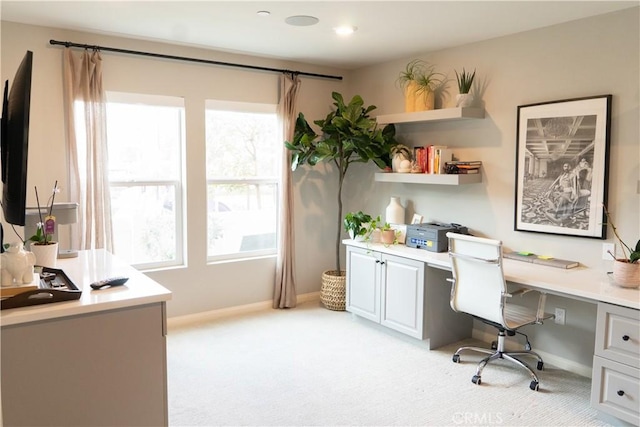 carpeted office space with built in desk