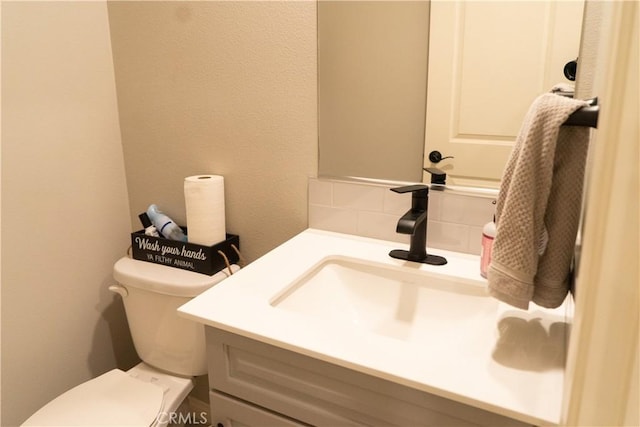 bathroom with tasteful backsplash, vanity, and toilet